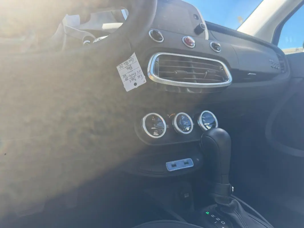 Intérieur de la Fiat 500X bleu, vue côté conducteur sur la console centrale avec levier de vitesse automatique et commandes de climatisation.