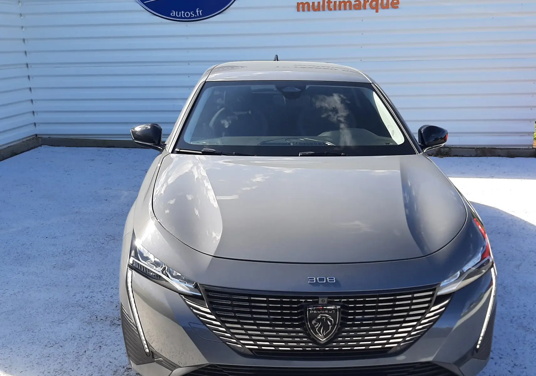 Vue avant frontale d'une Peugeot 308 SW gris selenium métal avec calandre noire et logo lion distinctif.