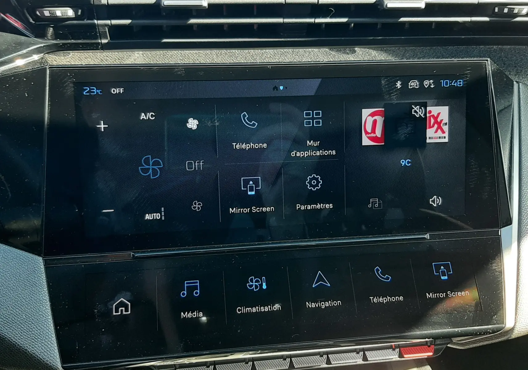 Vue rapprochée de l’écran tactile central du tableau de bord de la Peugeot 308 SW Hybrid 2025, affichant les commandes multimédia et climatisation.