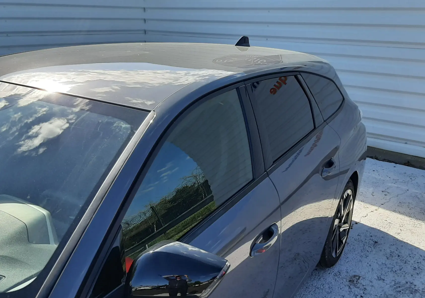 Vue 3/4 avant droit de la Peugeot 308 SW gris sélénium métal, avec vitres teintées et jantes alliage noires.