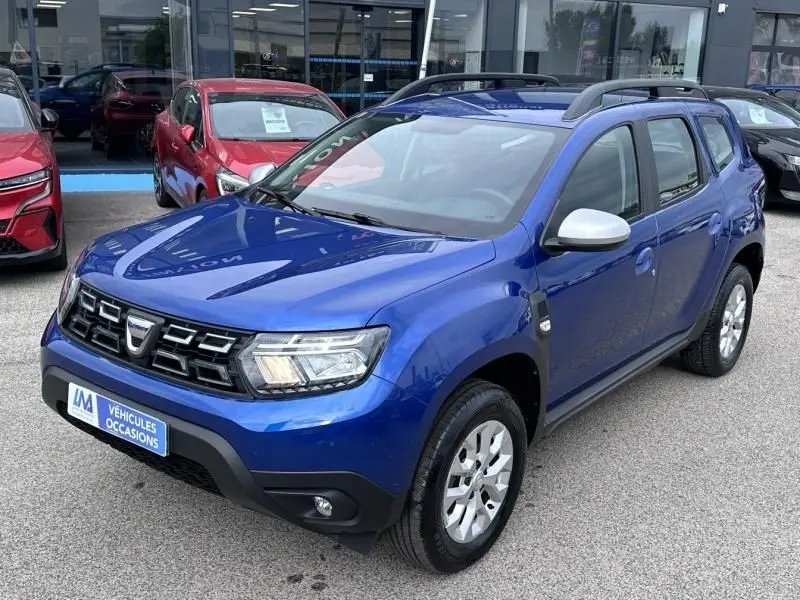 Dacia Duster bleu métal en 3/4 avant droit, version 1.0 ECO-G 100 ch Confort 4x2 avec rétroviseurs argentés.