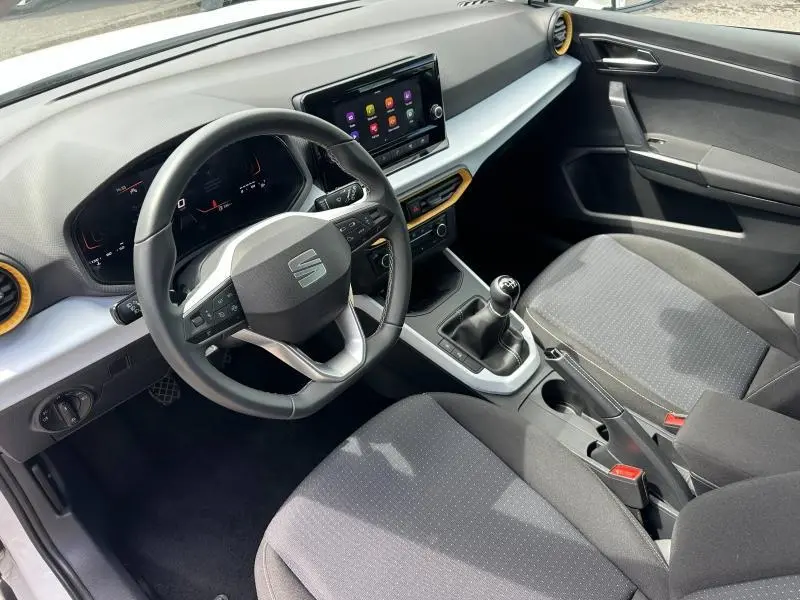Vue intérieure avant droite du SEAT Arona 2025, volant cuir multifonction et sièges tissu gris Como.