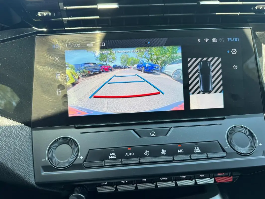 Écran tactile intérieur montrant la caméra de recul de la Peugeot 308 gris, avec affichage des aides au stationnement.