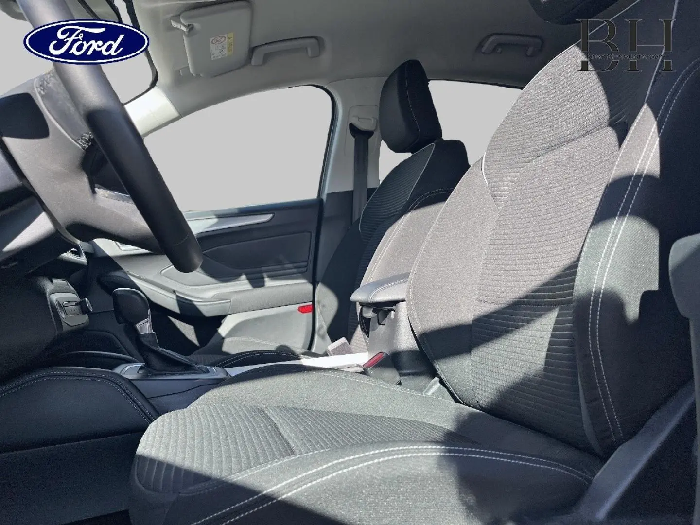 Intérieur de la Ford Focus 2022, vue côté droit sur les sièges tissu noir avec coutures blanches et accoudoir central.