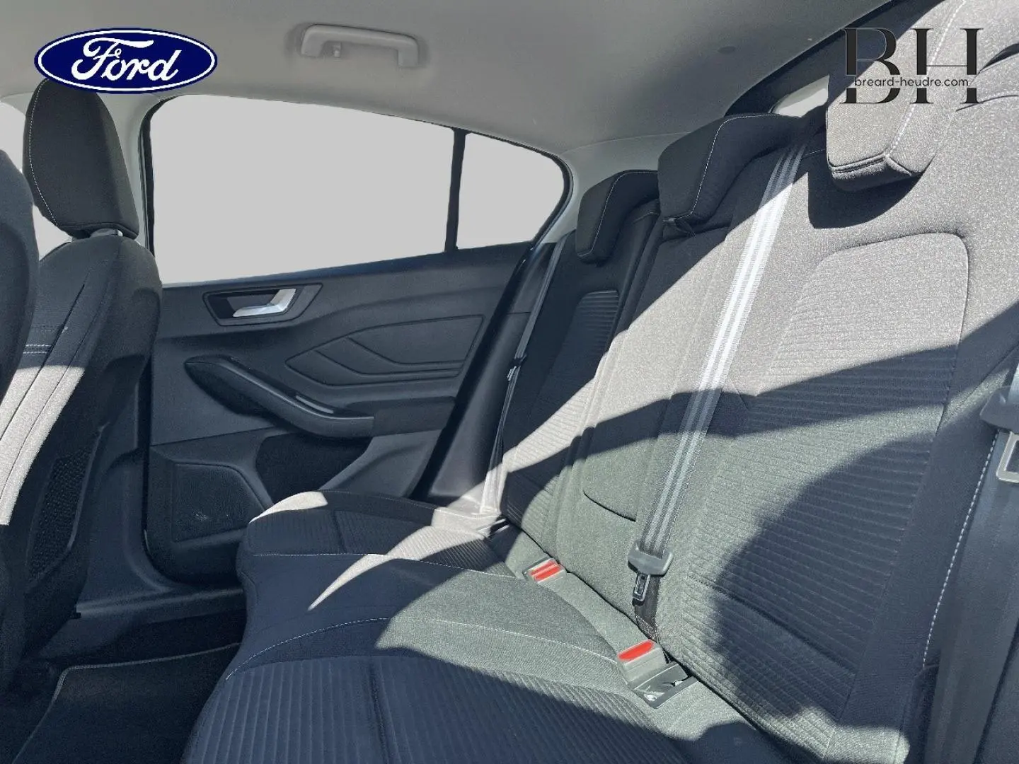 Vue latérale intérieure sur la banquette arrière en tissu noir avec surpiqûres blanches d'une Ford Focus 2022 gris lunaire.