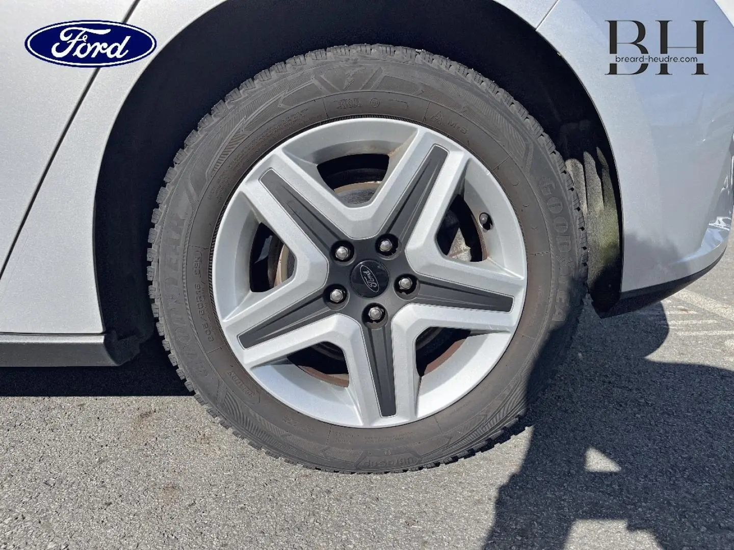 Gros plan sur la roue avant droite d'une Ford Focus gris lunaire métallisé avec jante alliage à cinq branches.