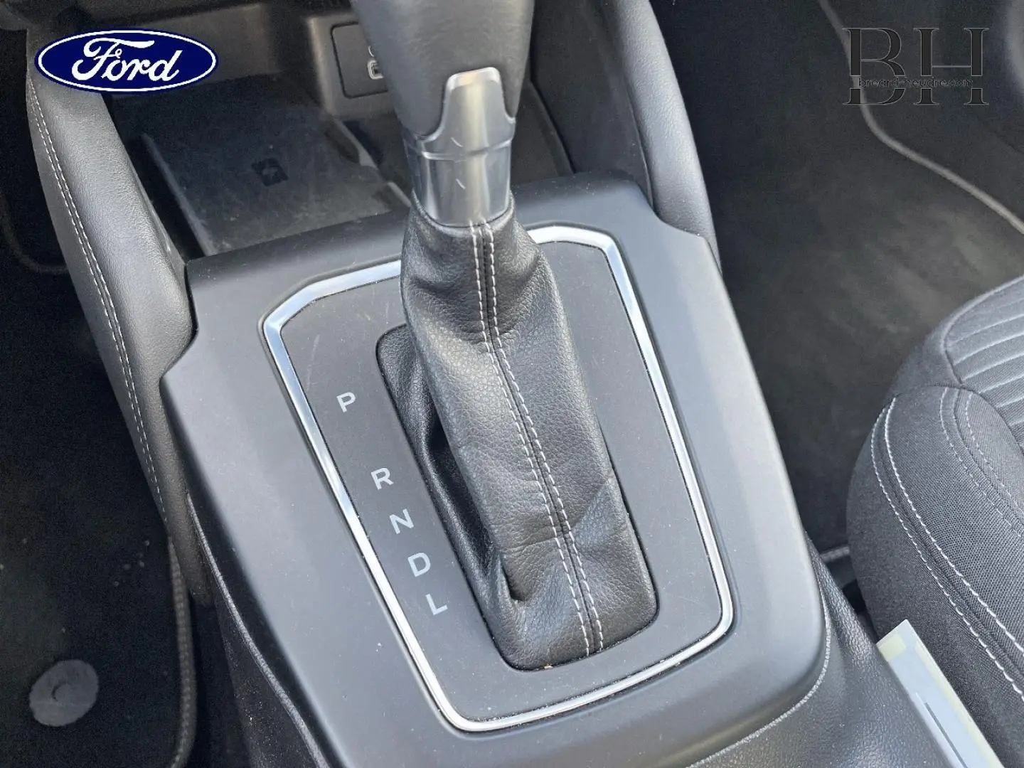 Gros plan sur la console centrale de la Ford Focus 2022, montrant le levier de vitesses automatique en cuir noir.