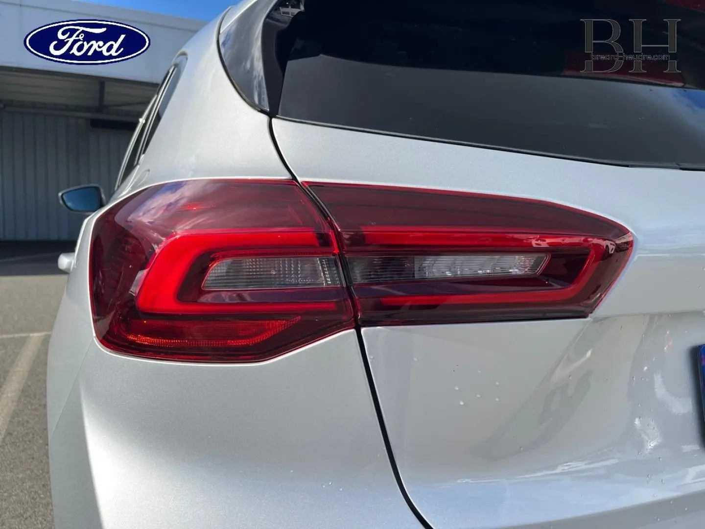 Gros plan sur le feu arrière gauche d’une Ford Focus gris lunaire métallisé, soulignant la finition moderne du modèle 2022.