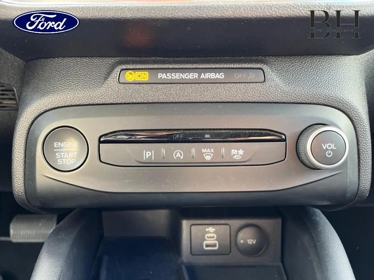 Vue rapprochée du tableau de bord central de la Ford Focus gris lunaire, avec bouton start/stop et commandes audio.