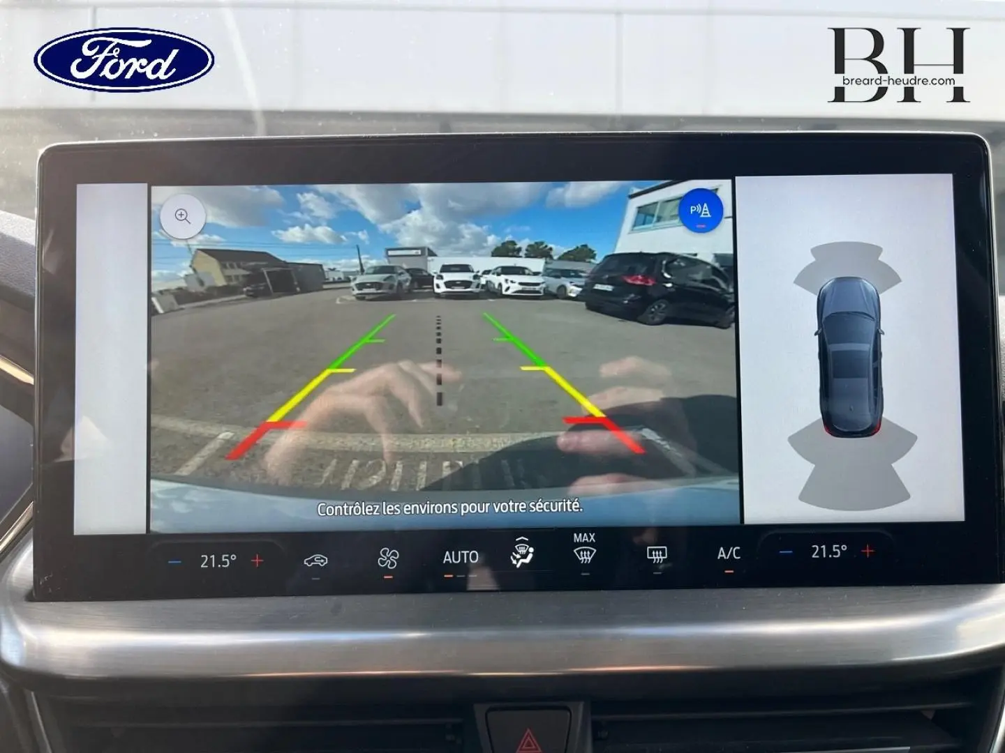Écran tactile intérieur montrant la caméra de recul et l’aide au stationnement de la Ford Focus gris lunaire métallisé.