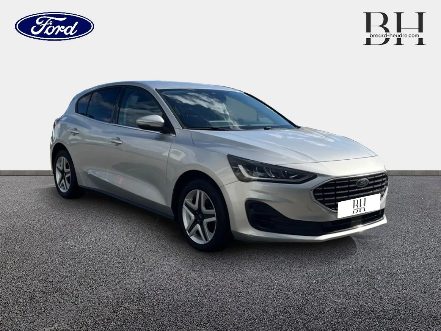 Vue 3/4 avant gauche d'une Ford Focus 2022 gris lunaire métallisé avec calandre noire et jantes alliage.