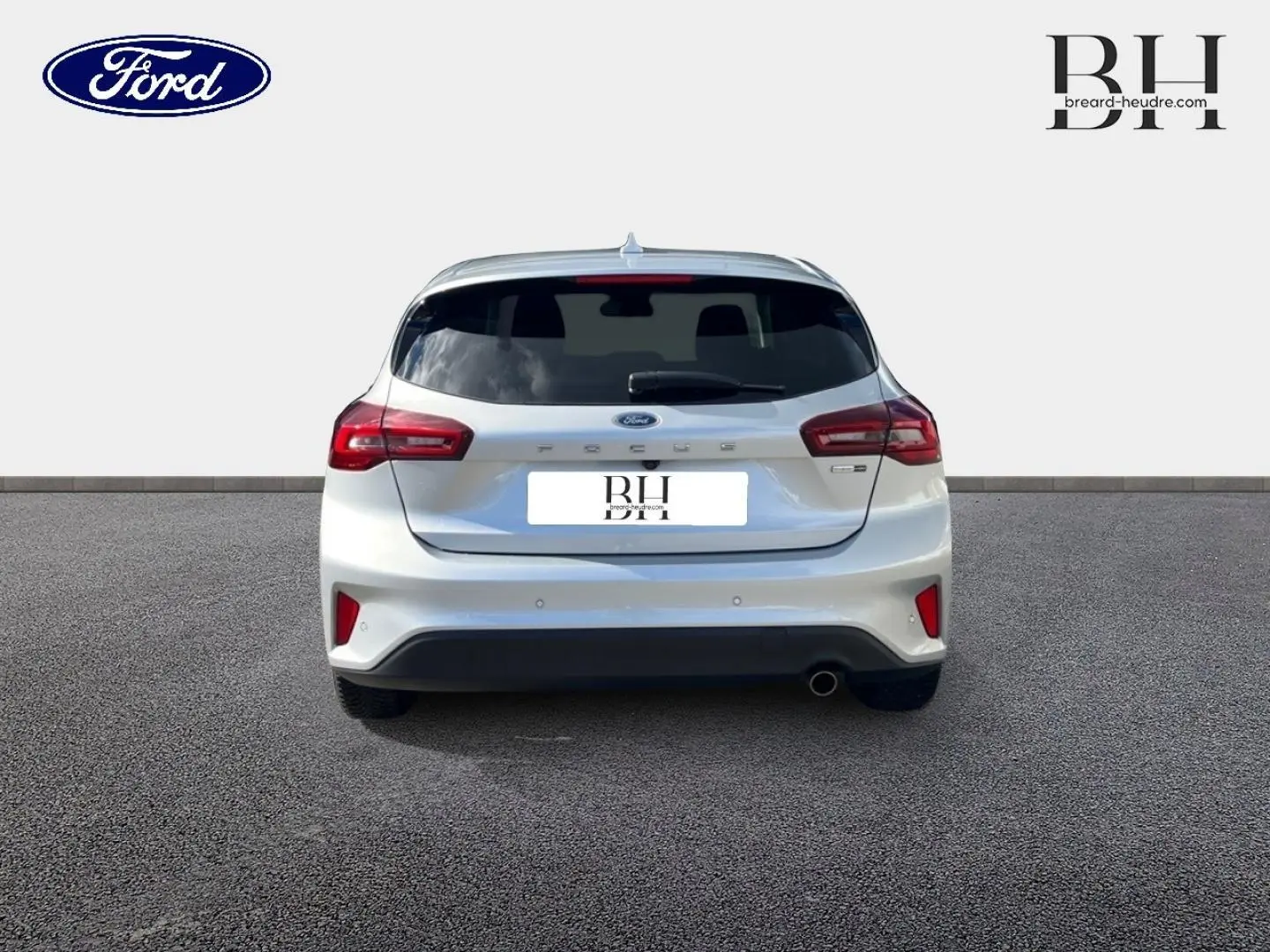 Vue arrière d'une Ford Focus gris lunaire métallisé 2022 avec feux rouges et lunette arrière surteintée.