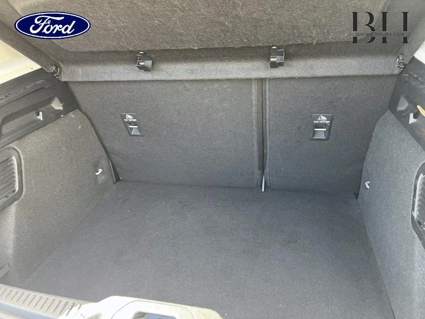 Coffre vide de Ford Focus 2022 gris lunaire, vue intérieure arrière montrant la banquette rabattable et fixations Top Tether.