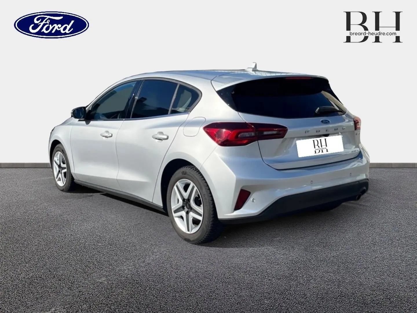 Vue 3/4 arrière droite d'une Ford Focus gris lunaire métallisé avec vitres arrière surteintées et feux arrière LED distinctifs.