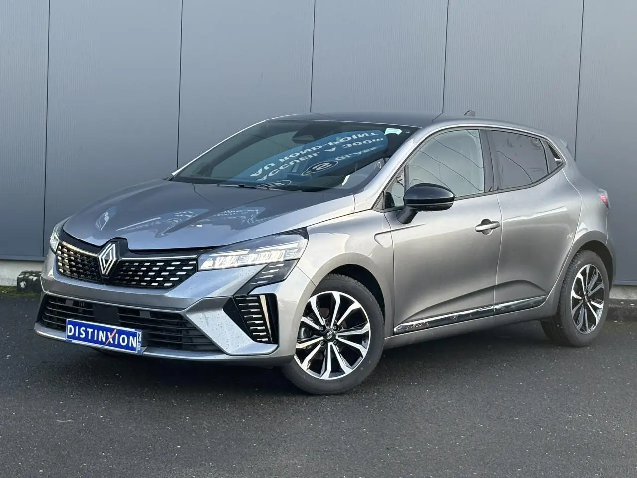 Renault Clio V TCe 90 Techno gris schiste vue 3/4 avant droit, avec jantes alliage et signature lumineuse LED.