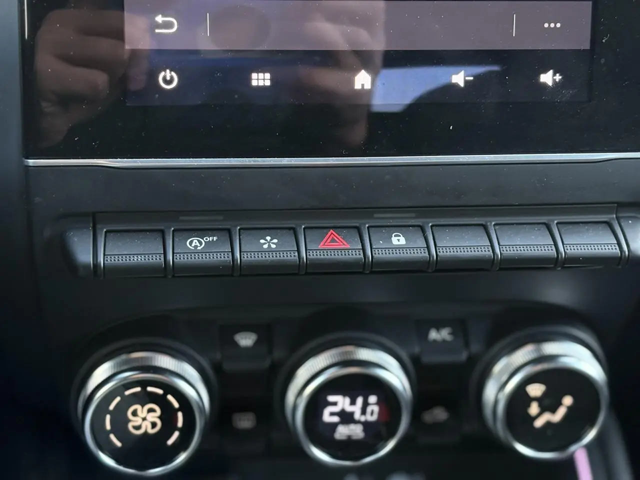 Gros plan sur la console centrale de la Renault Clio 2025 gris schiste, montrant les commandes de climatisation et les boutons de fonction.