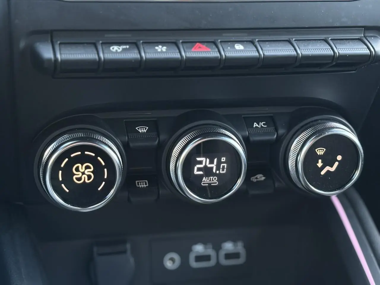 Gros plan sur les commandes de climatisation automatique de la Renault Clio 2025, avec affichage digital à 24°C.