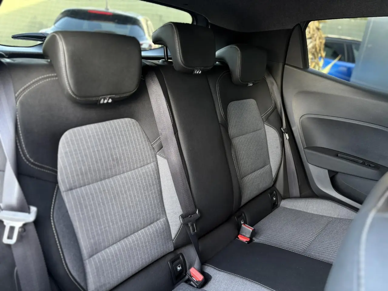 Vue intérieure arrière droite des sièges tissu gris et noir de la Renault Clio V TCe 90 Techno 2025.
