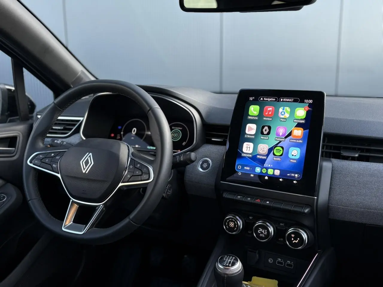 Vue intérieure centrée sur le volant multifonction et l’écran tactile 9,3 pouces de la Renault Clio gris schiste.