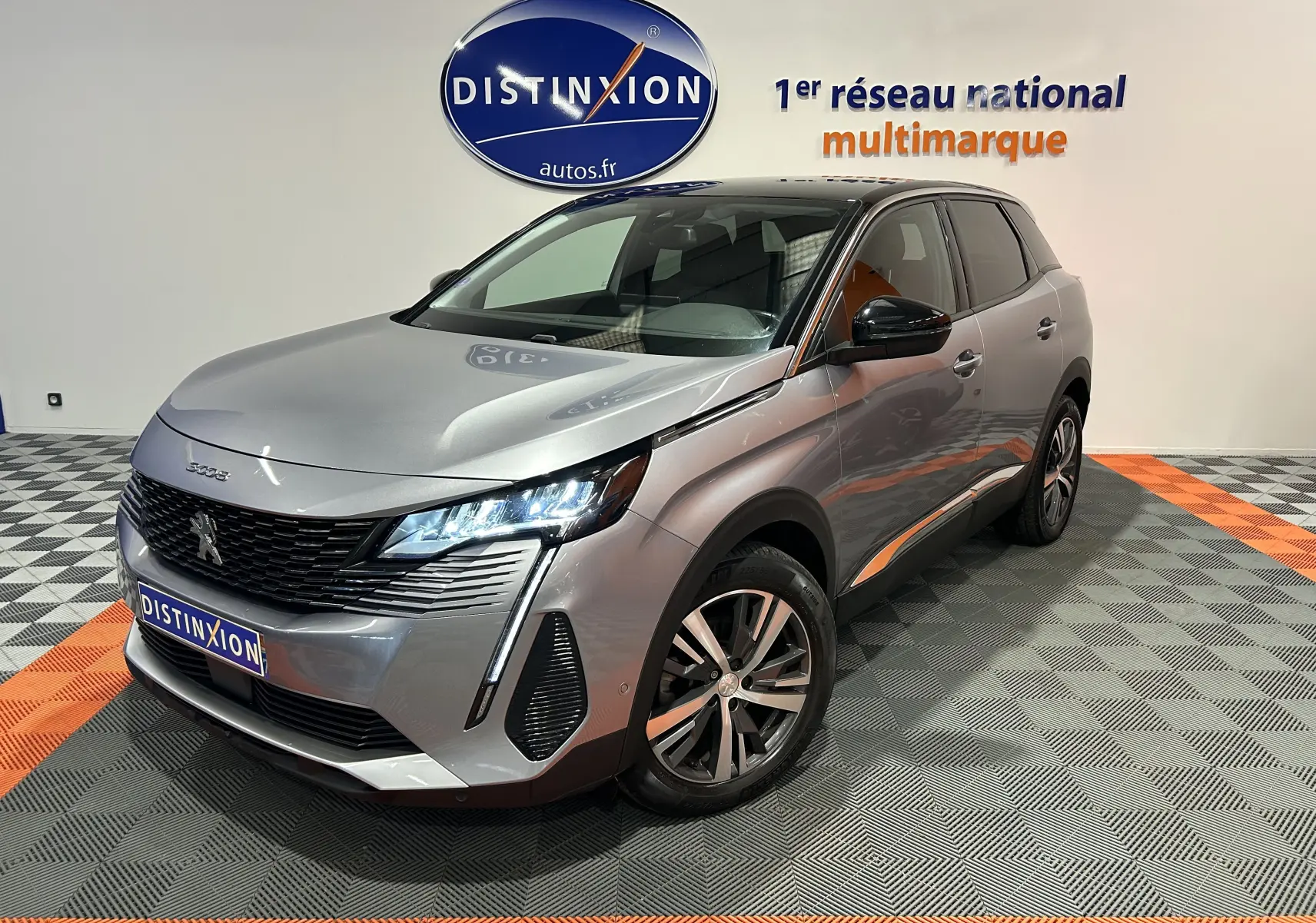 Peugeot 3008 Puretech 130 gris Artense avec toit noir, vue 3/4 avant droit en intérieur showroom.