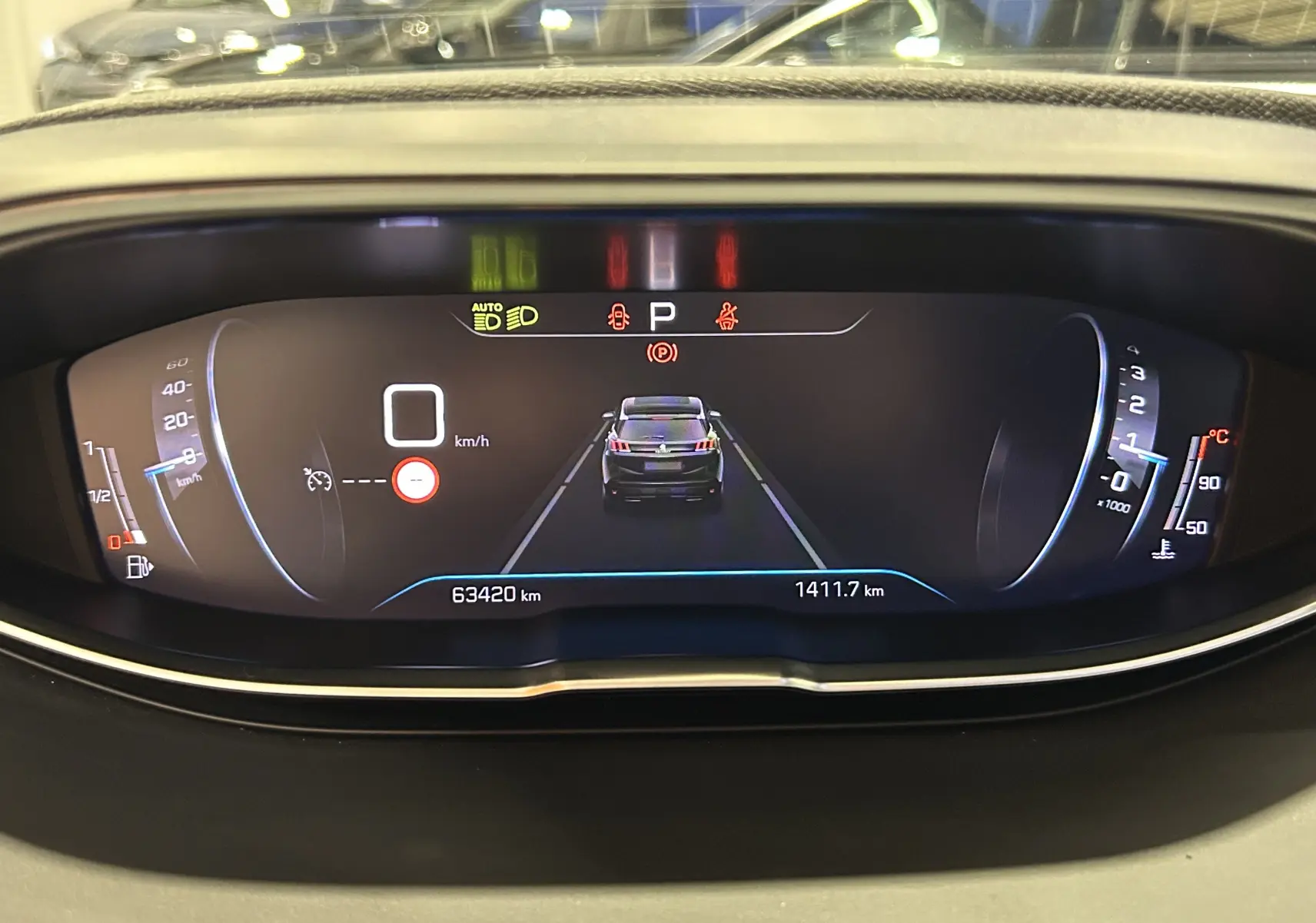 Tableau de bord numérique du Peugeot 3008 affichant la vitesse à 0 km/h et un visuel arrière du véhicule en gris.