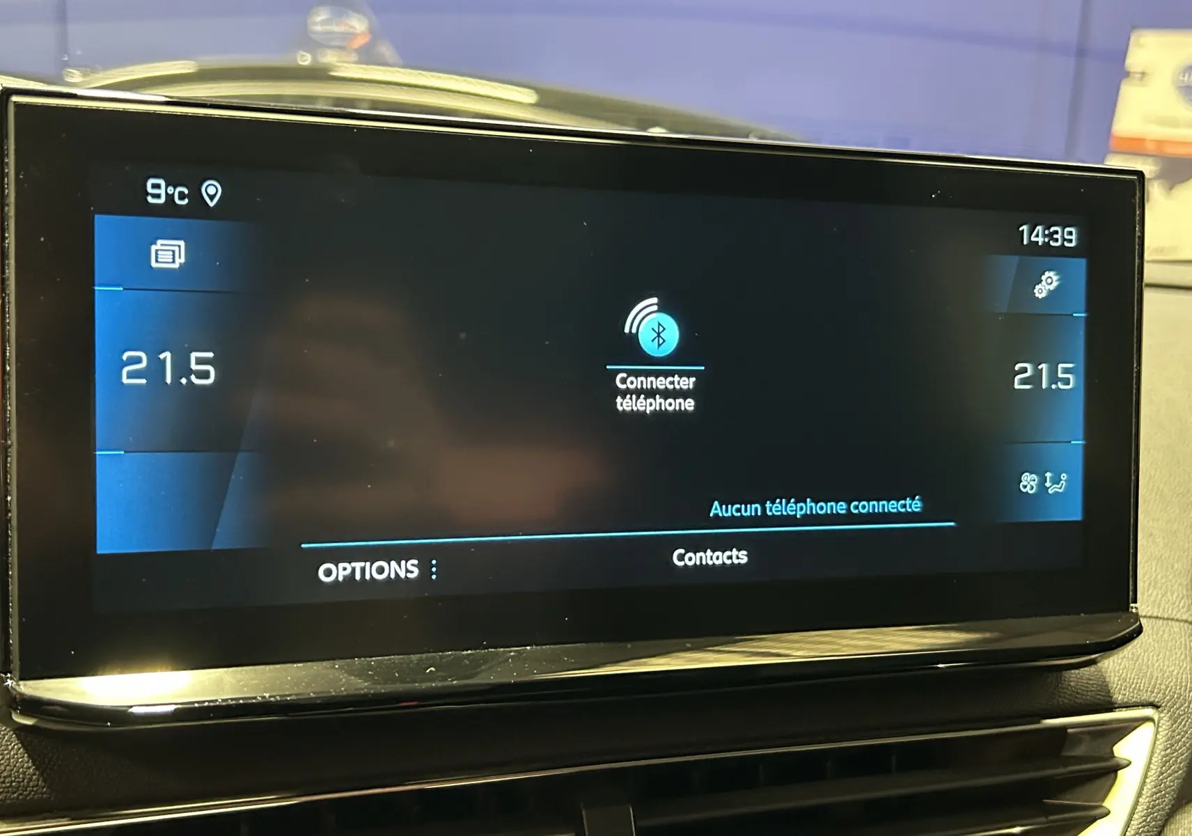 Écran tactile central du tableau de bord du Peugeot 3008 gris, affichant la connexion Bluetooth et la température à 21,5°C.