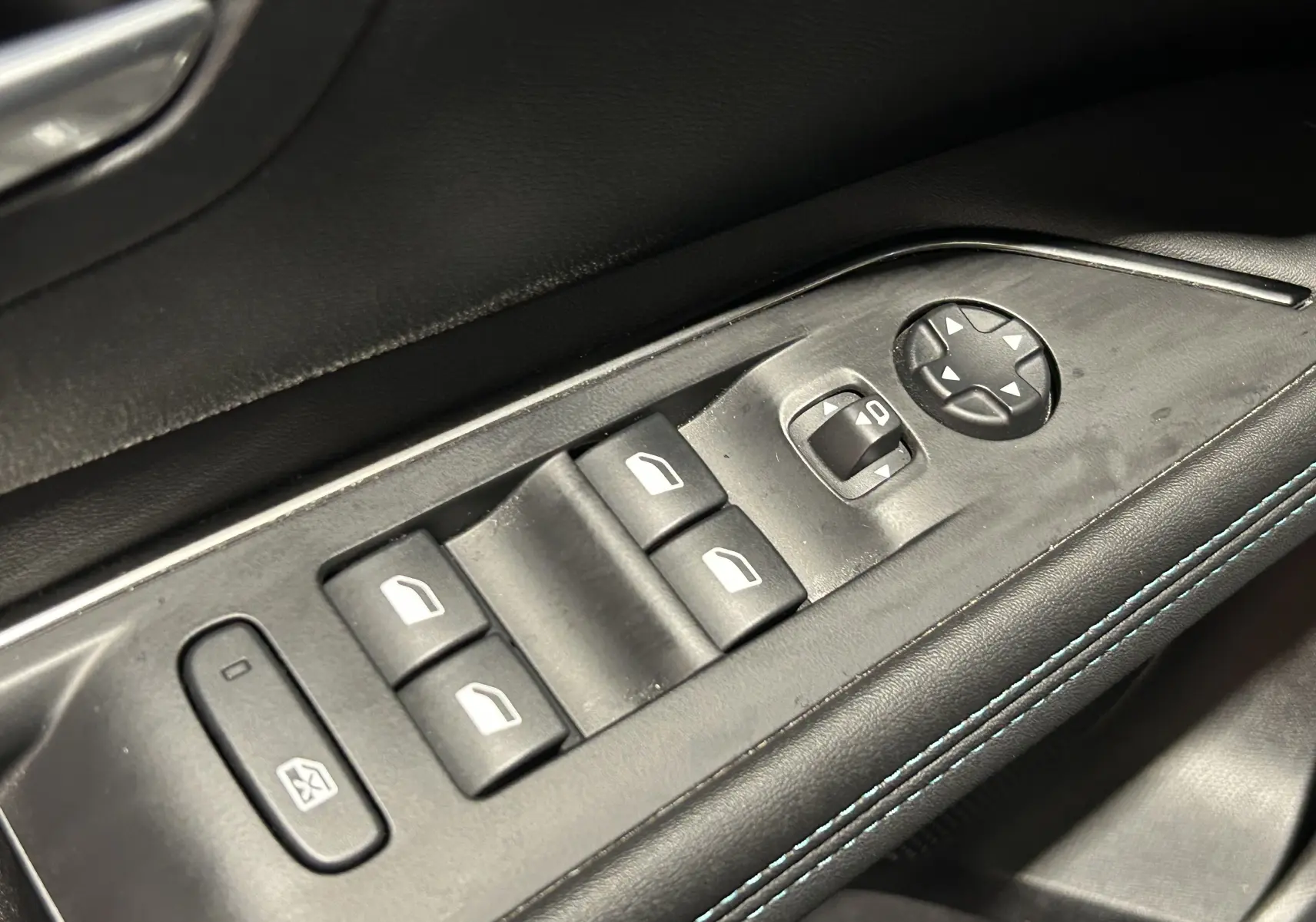 Détail des commandes de lève-vitres et réglages des rétroviseurs sur la porte avant gauche du Peugeot 3008 gris Artense.