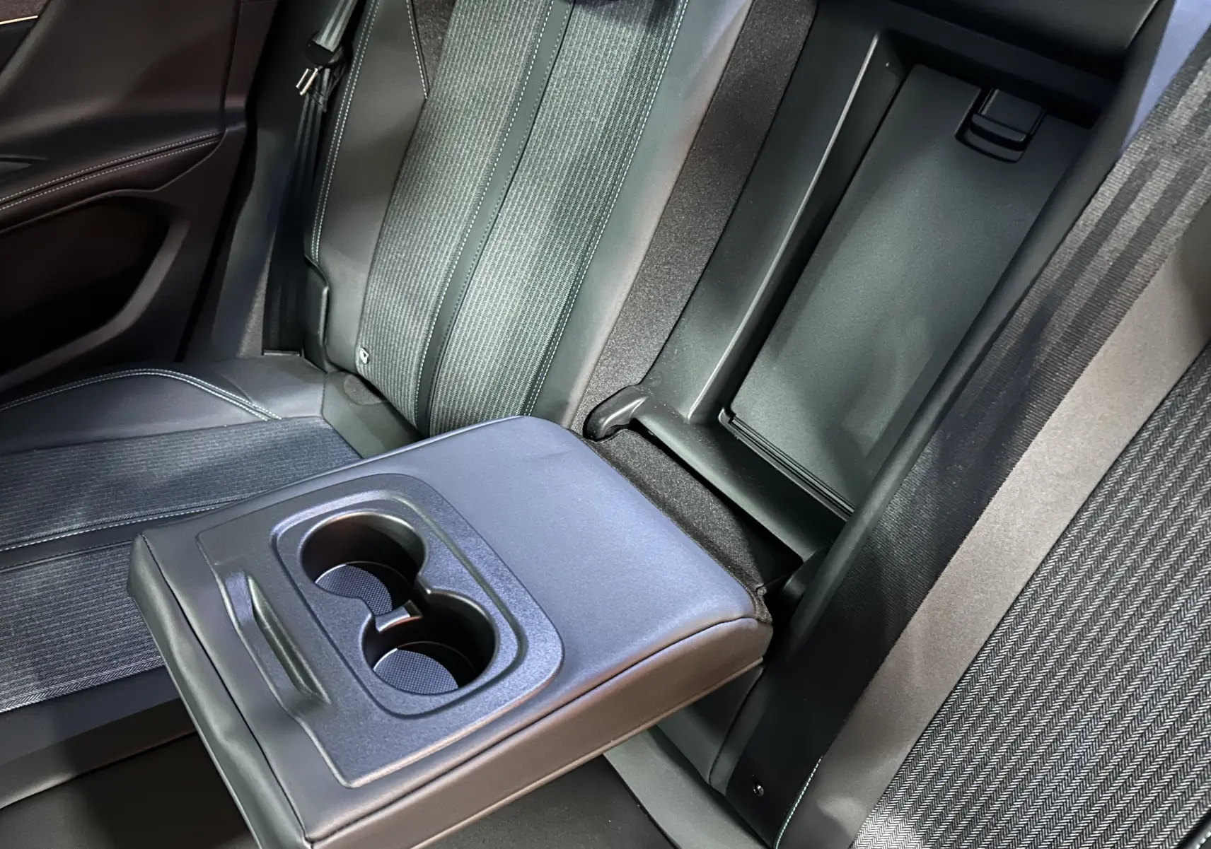 Détail de l'accoudoir central arrière avec porte-gobelets sur la banquette tissu gris du Peugeot 3008 2022.