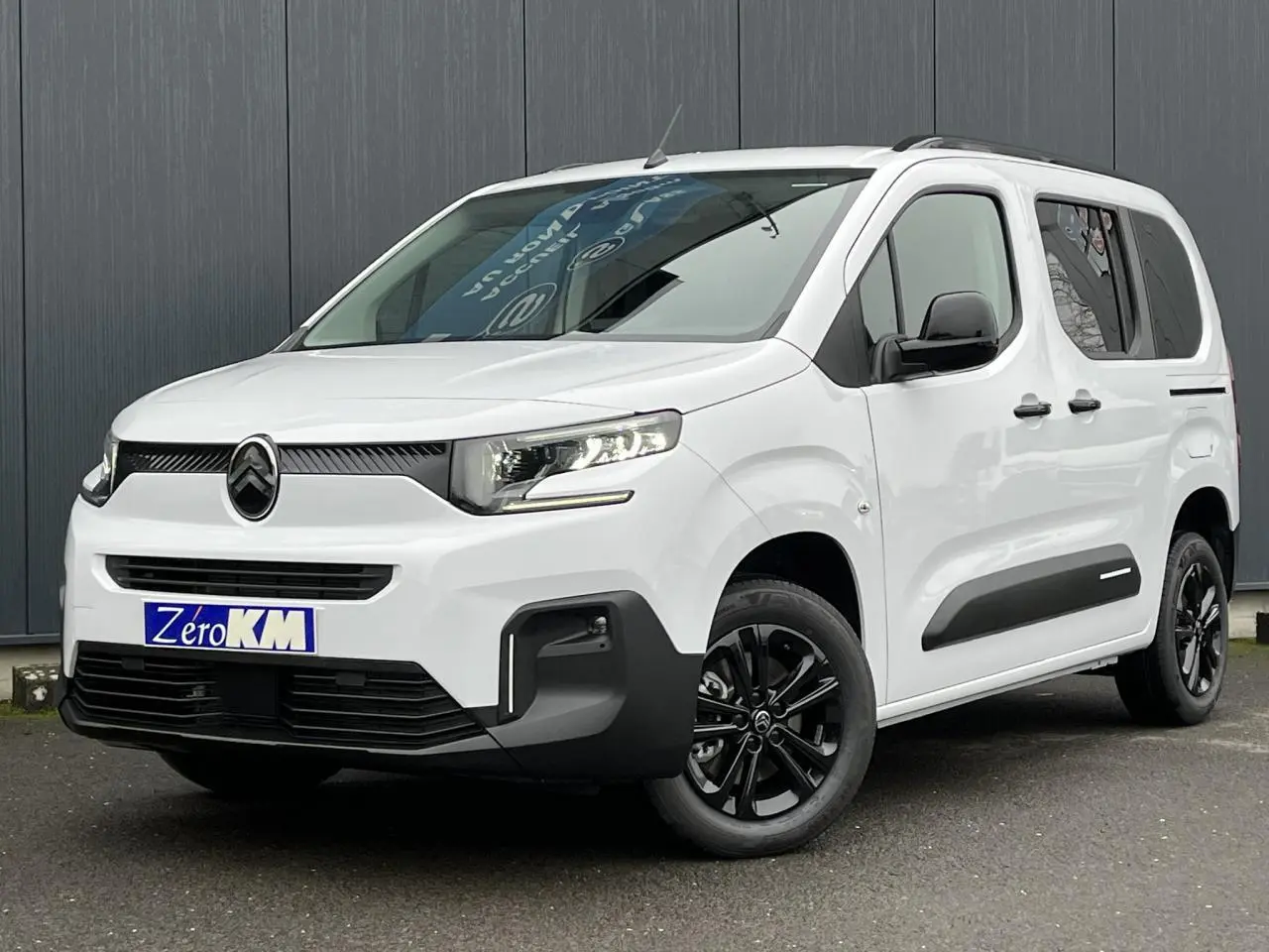 Citroën Berlingo Multispace blanc glacier en 3/4 avant droit avec jantes noires et barres de toit.