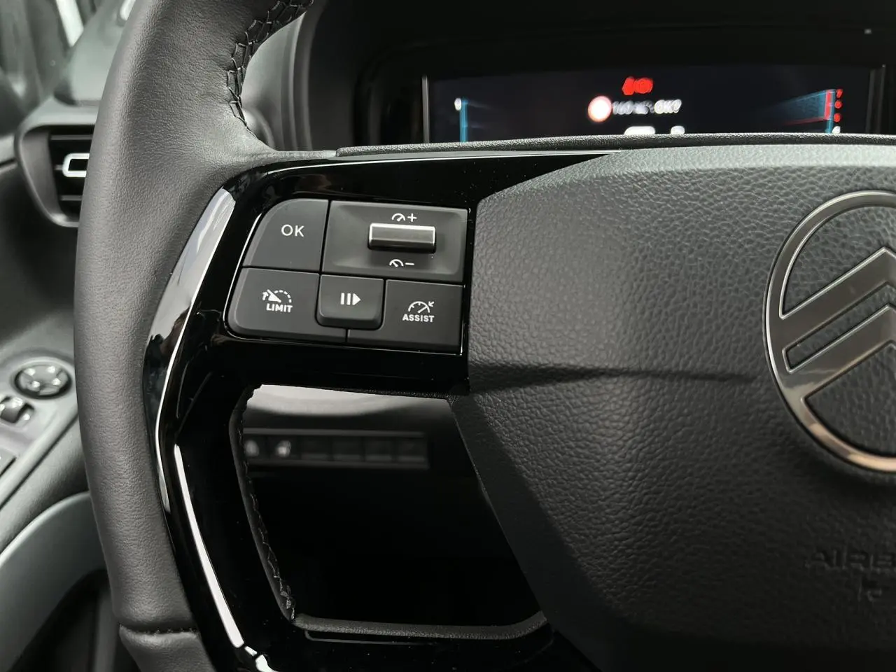 Gros plan sur le volant cuir noir du Citroën Berlingo Multispace 2025, avec commandes multifonctions à gauche.