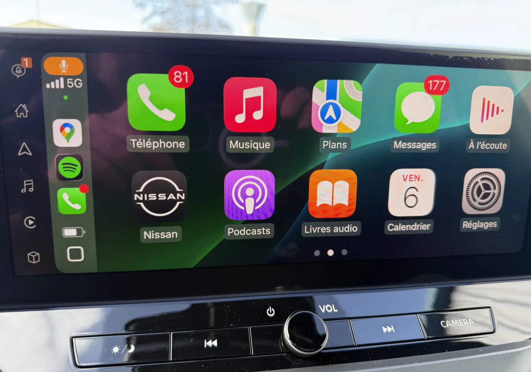 Écran tactile intérieur du Nissan Juke 2025 affichant les applications Apple CarPlay avec commandes audio en dessous.