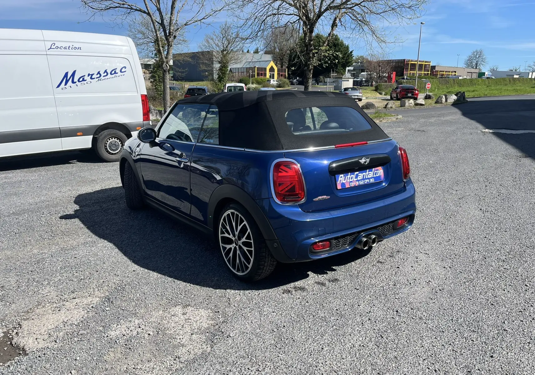 Vue 3/4 arrière droite d'une MINI Cabriolet F57 Cooper S bleu avec capote noire et jantes alliage multibranches.