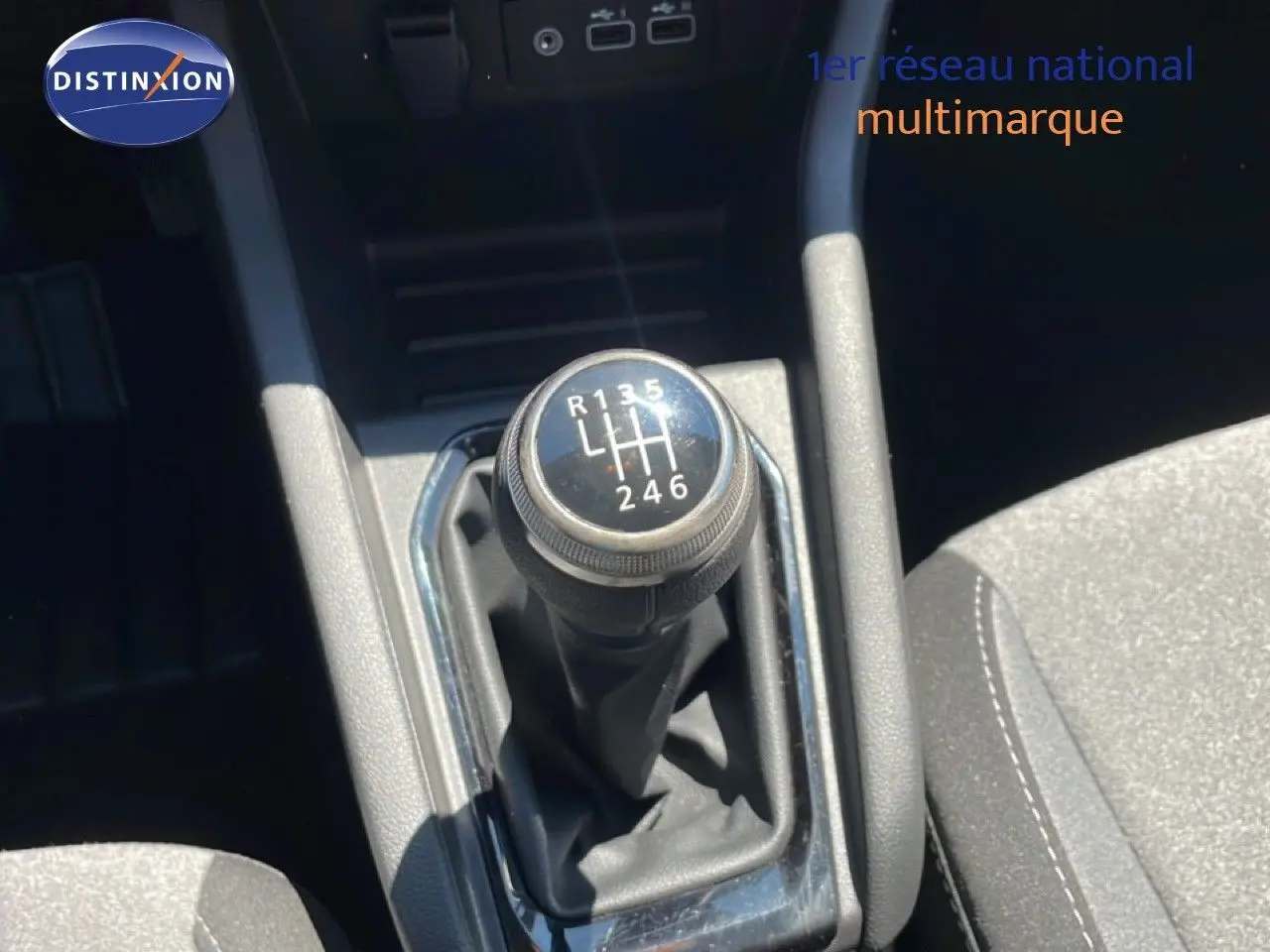 Gros plan sur le levier de vitesses manuel de la Renault Clio 2025, finition noire avec coutures blanches visibles sur le siège.