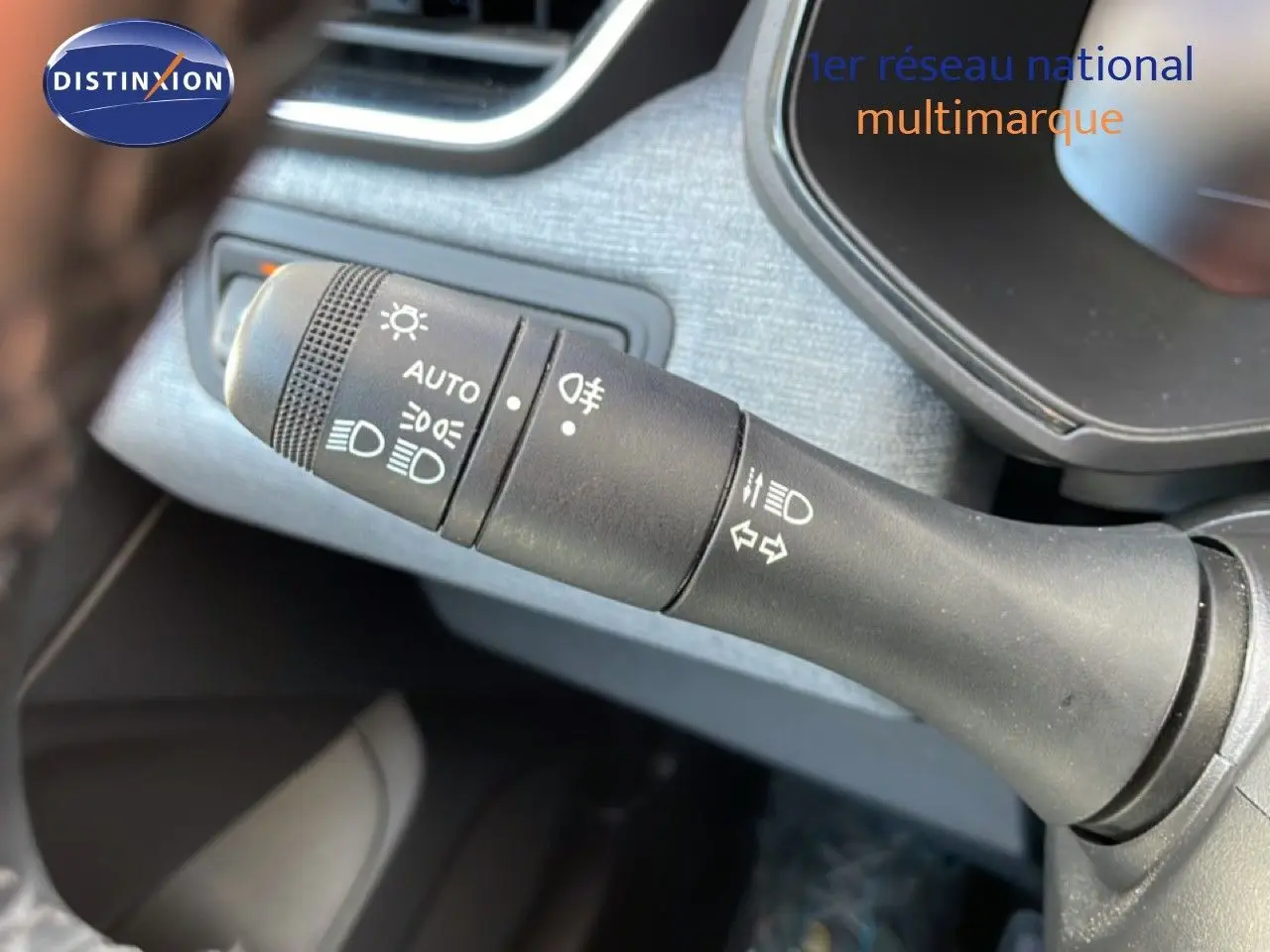 Gros plan sur la commande des phares et clignotants dans l'habitacle d'une Renault Clio noir étoile métal 2025.