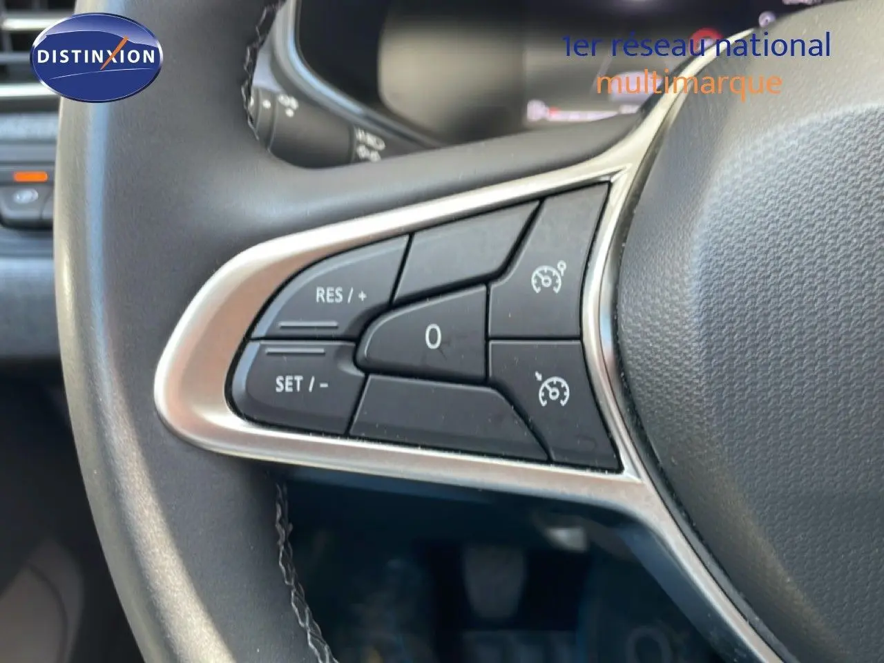 Gros plan sur les commandes au volant à gauche de la Renault Clio noire Étoile Metal, montrant les boutons de régulateur de vitesse.