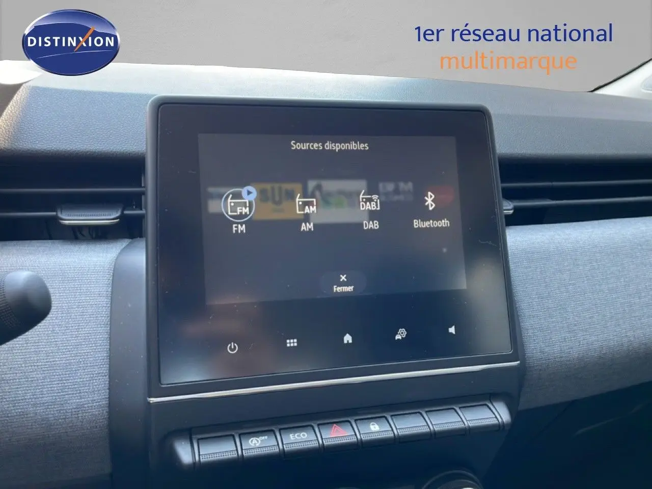 Vue intérieure centrée sur l’écran tactile multimédia et la planche de bord grise de la Renault Clio noire 2025.