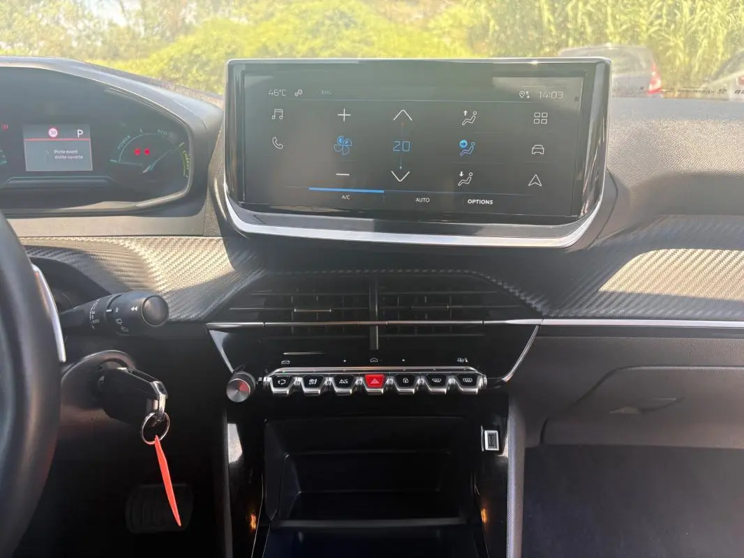 Vue intérieure frontale du tableau de bord de la Peugeot 2008 gris, avec écran tactile et commandes en rangée.