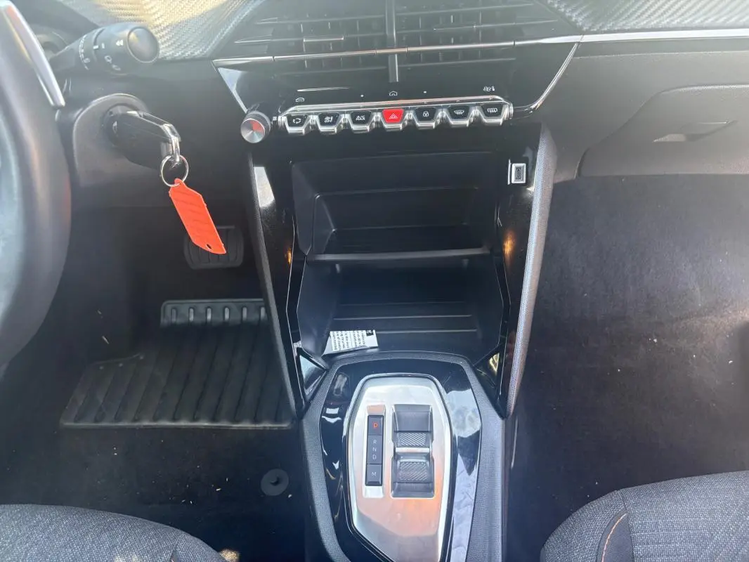 Vue intérieure centrée sur la console centrale noire du Peugeot 2008 Hybrid 145 e-DCS6 Style avec levier de boîte auto.
