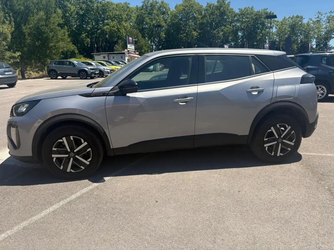 Peugeot 2008 Hybrid 145 Style gris vue de profil côté gauche, avec jantes 16 pouces et toit blanc contrasté.
