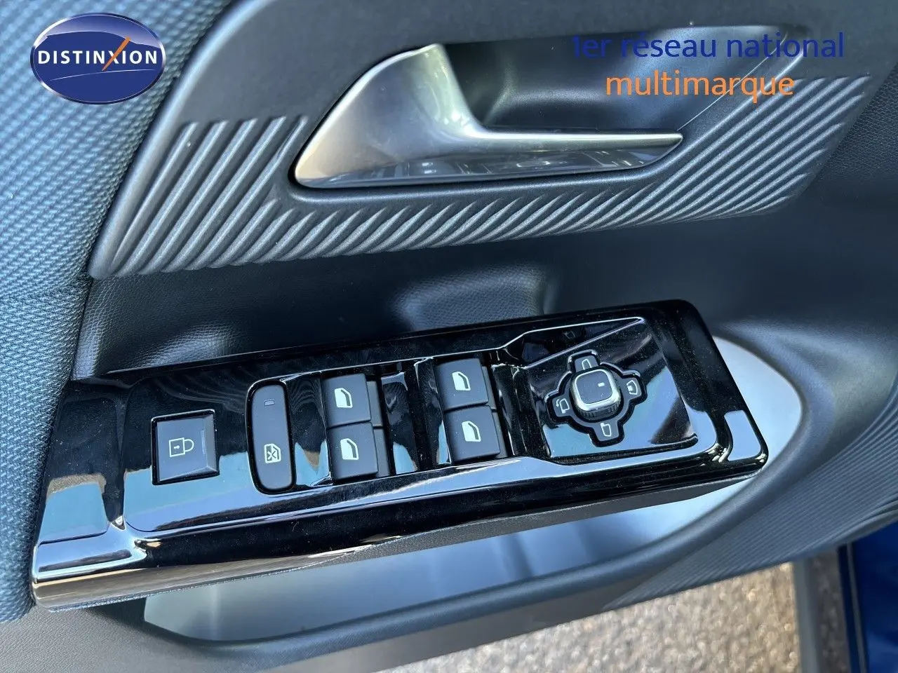 Gros plan sur les commandes de lève-vitres et réglages des rétroviseurs côté conducteur du Citroën C5 Aircross Hybrid 2026 bleu Eclipse métal.