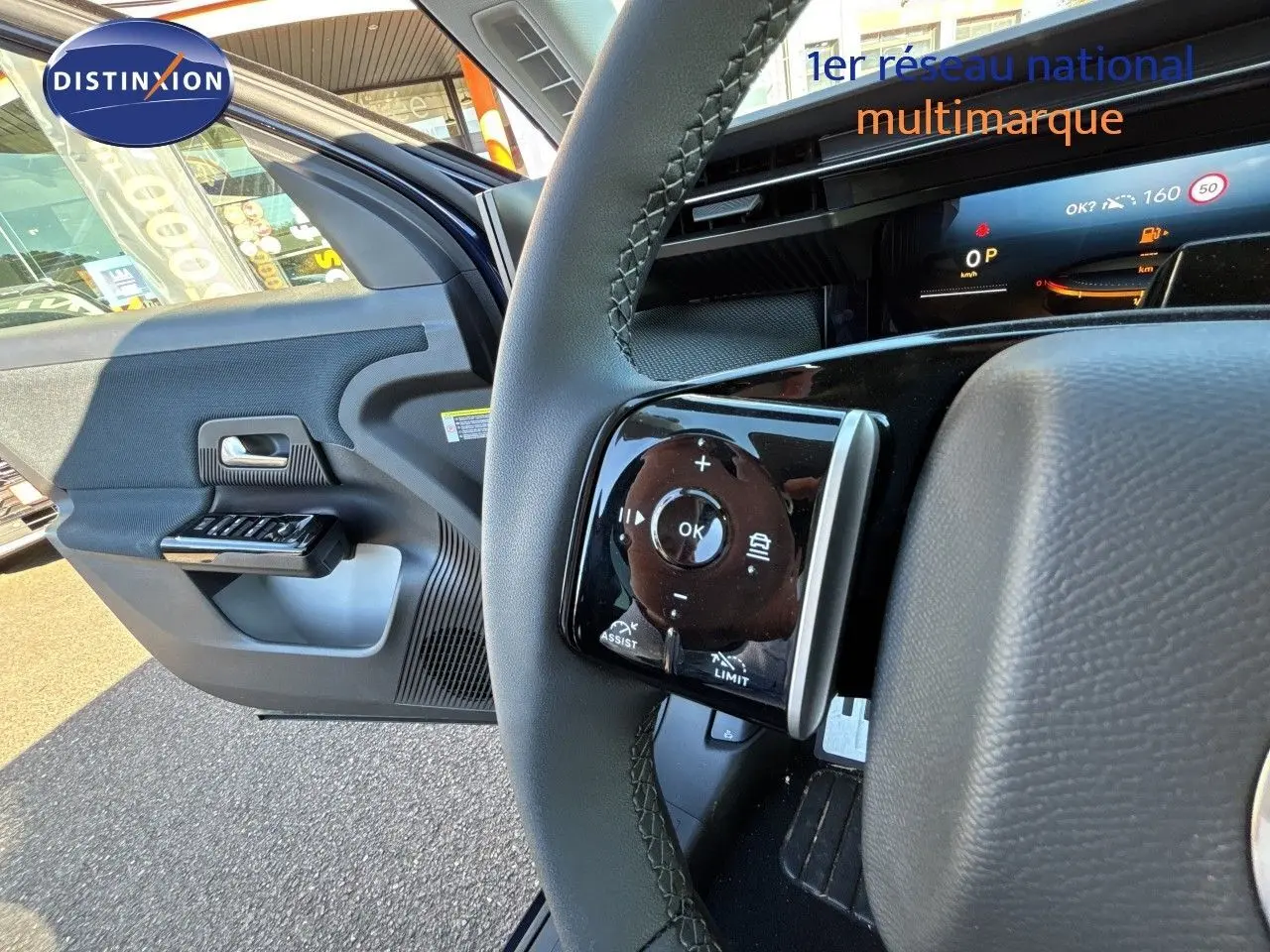 Gros plan sur le volant et la portière ouverte côté gauche d’un Citroën C5 Aircross Hybrid bleu Eclipse métal avec toit noir.