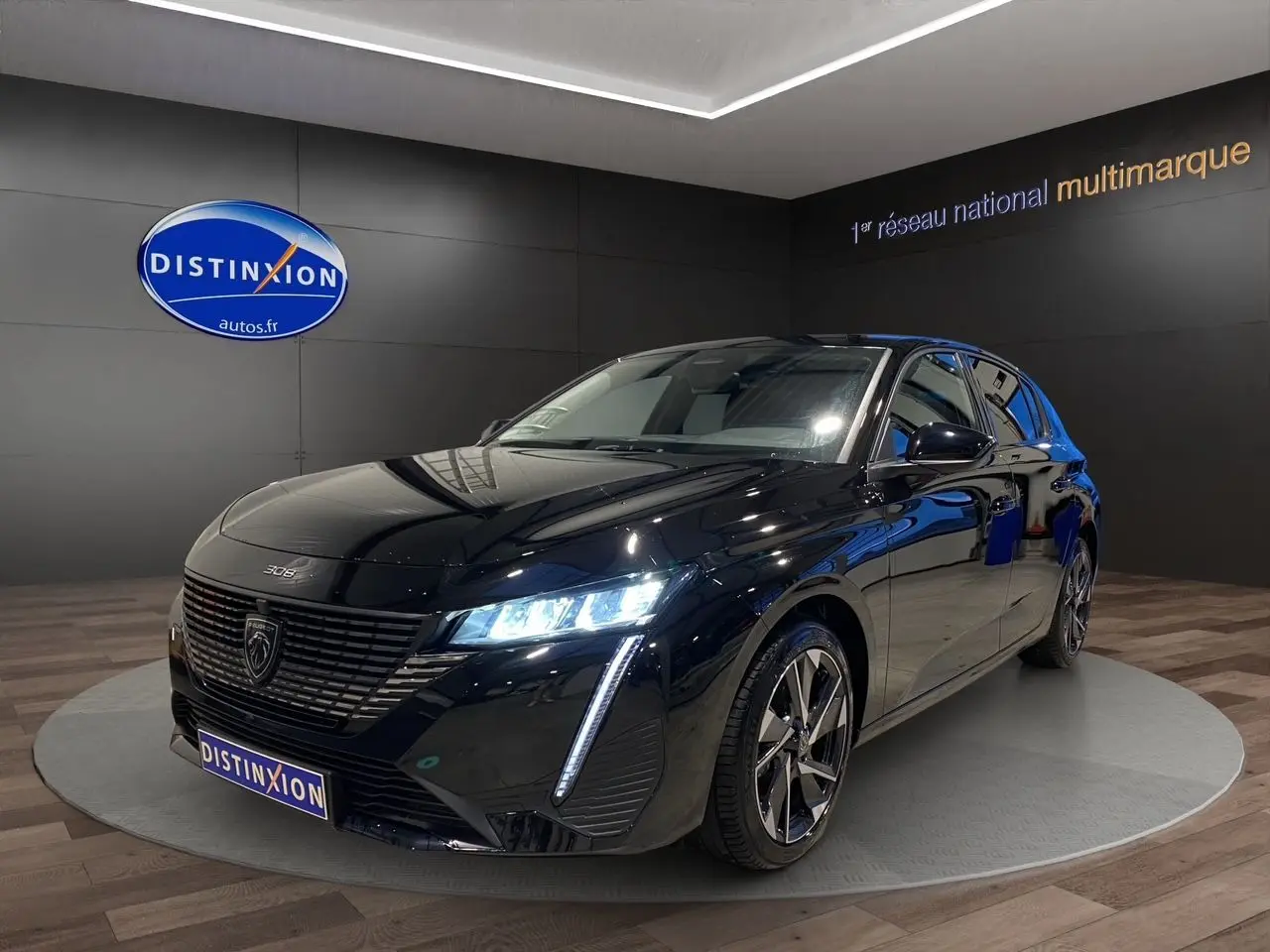 Peugeot 308 noir Perla Nera vue 3/4 avant droit, phares LED allumés et jantes alliage distinctives.