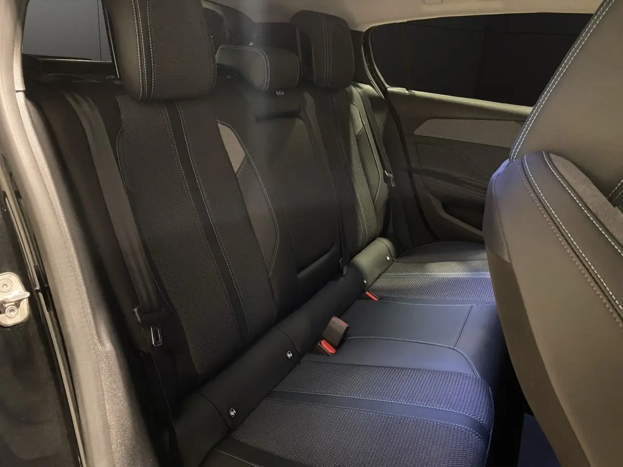 Vue intérieure côté gauche des sièges arrière noirs en tissu et cuir de la Peugeot 308 2024.