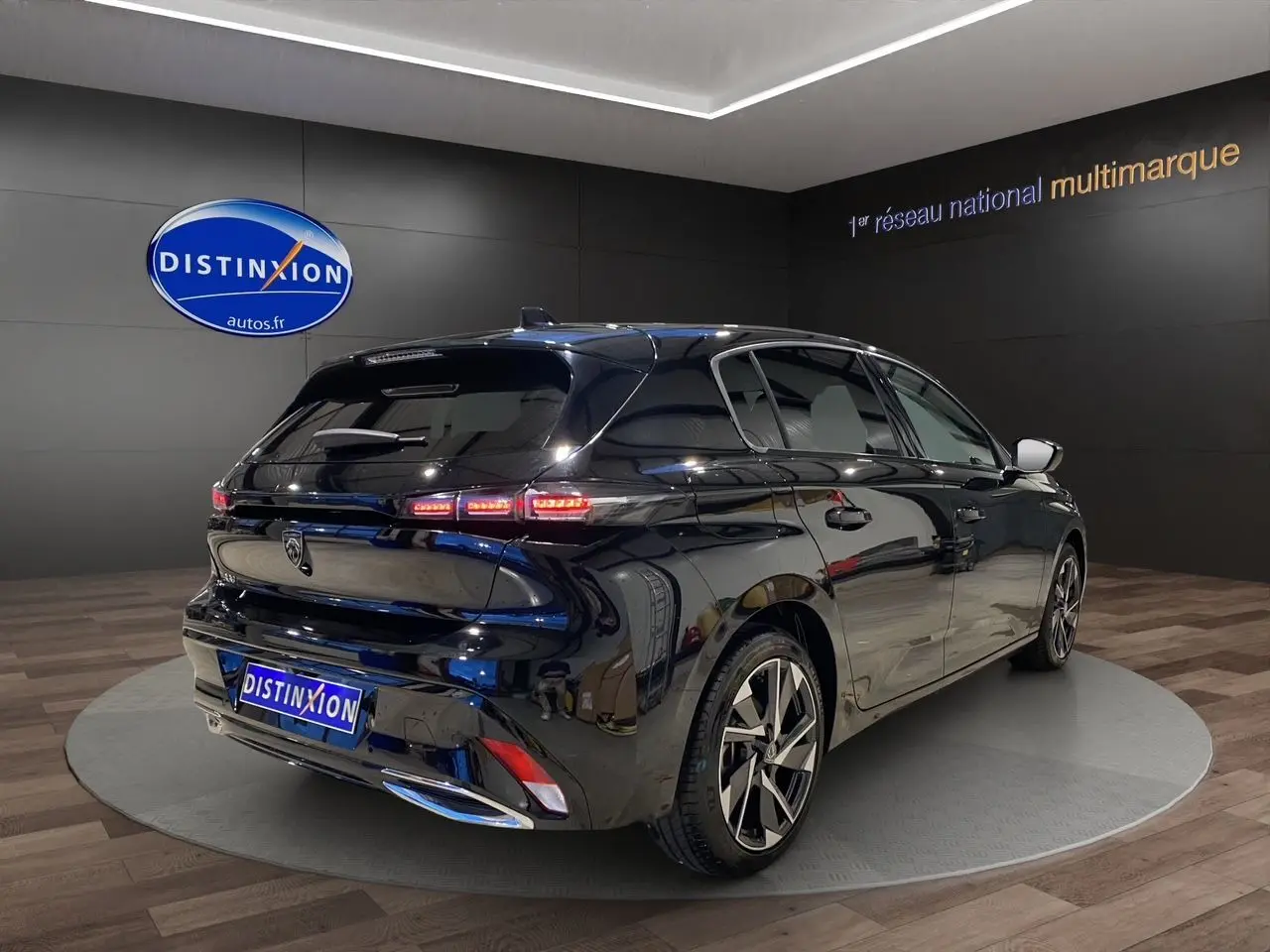 Vue 3/4 arrière droite d'une Peugeot 308 noire Perla Nera 2024 avec feux LED et jantes alliage distinctives.