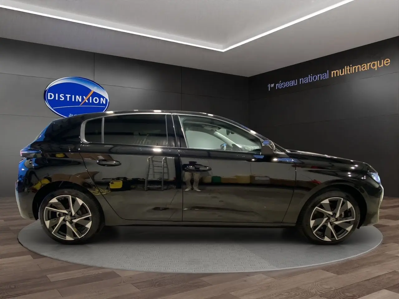 Profil droit d'une Peugeot 308 noire Perla Nera 5 portes, avec jantes alliage et intérieur clair visible.