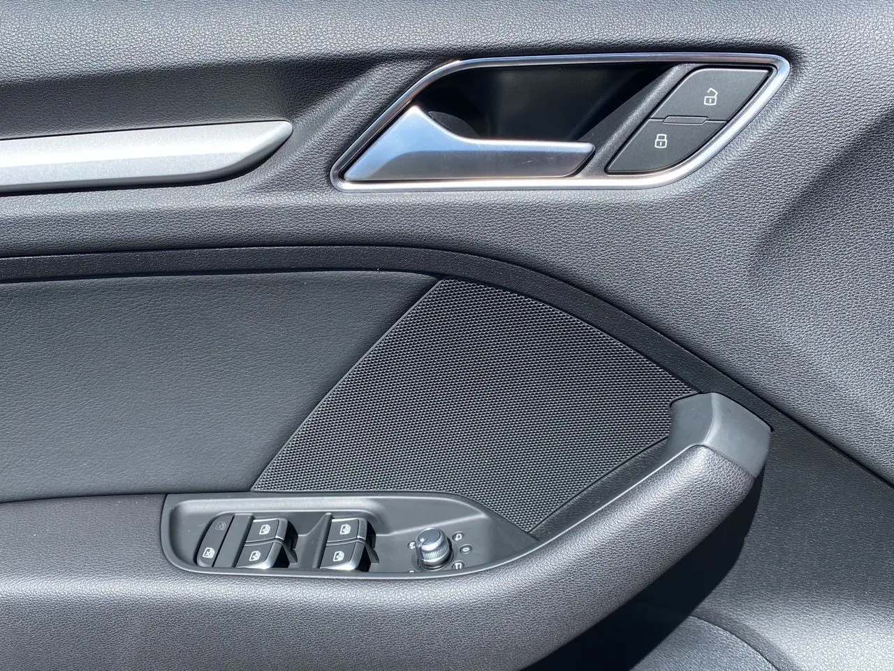 Détail de la porte côté gauche de l'Audi A3 Sportback 2020 noire, avec commandes de vitres et verrouillage.