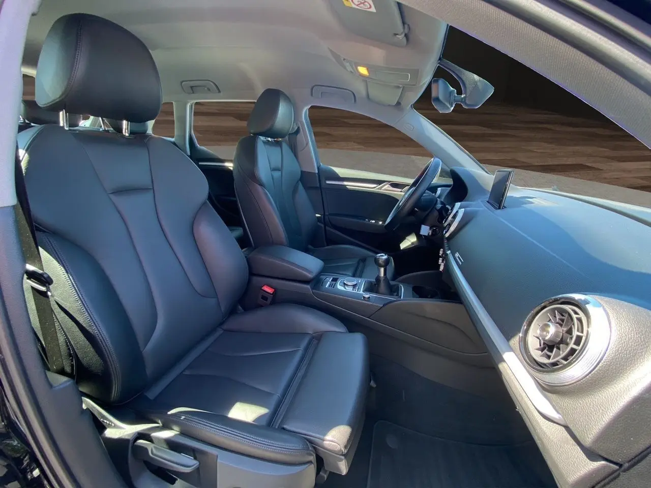 Intérieur avant d'une Audi A3 Sportback 2020 avec sellerie cuir noir chauffant et console centrale manuelle visible.