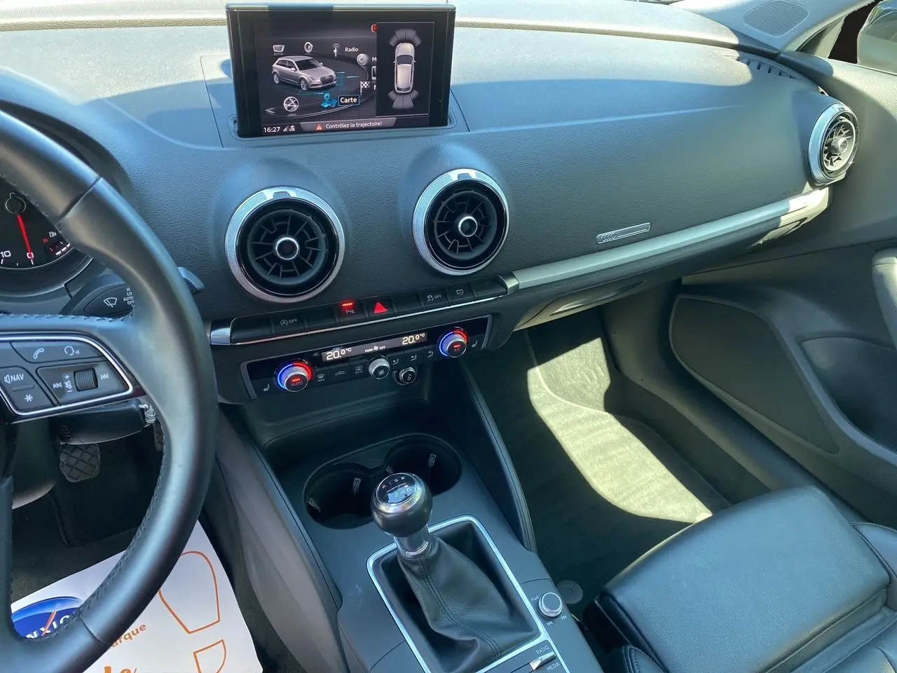 Intérieur Audi A3 Sportback 2020 noir, vue du poste de conduite avec écran multimédia et levier de vitesse manuel.