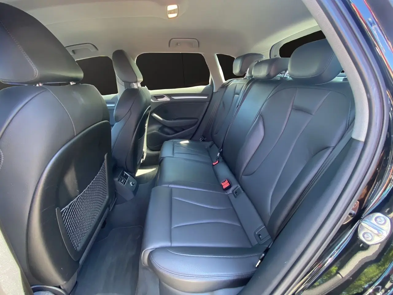 Vue intérieure côté droit montrant la banquette arrière en cuir noir de l'Audi A3 Sportback 2020.