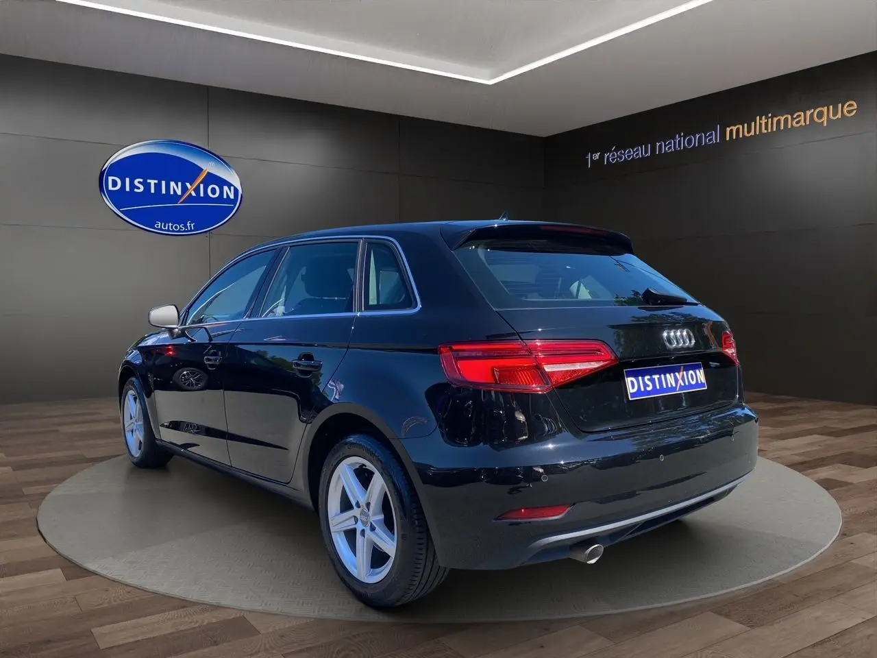 Audi A3 Sportback noire vue 3/4 arrière droit, avec feux arrière LED et jantes alliage 5 branches.